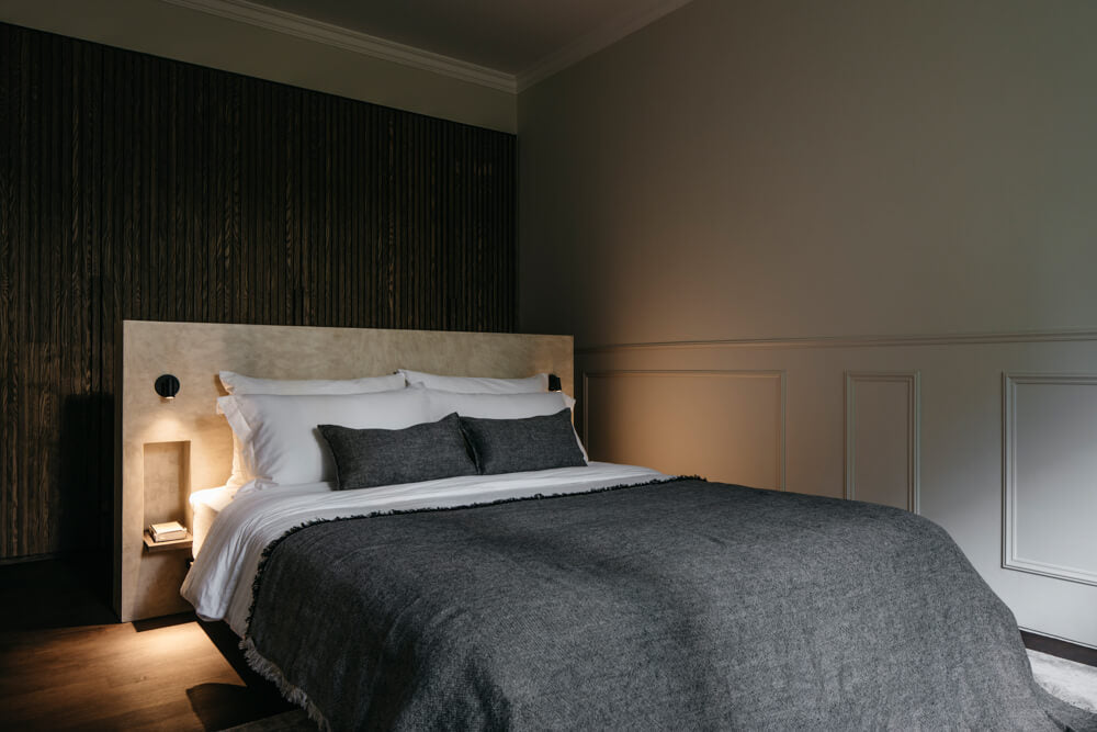 A bedroom with a dark slatted wall finished with Rubio Monocoat Oil Plus 2C hardwax oil wood finish.