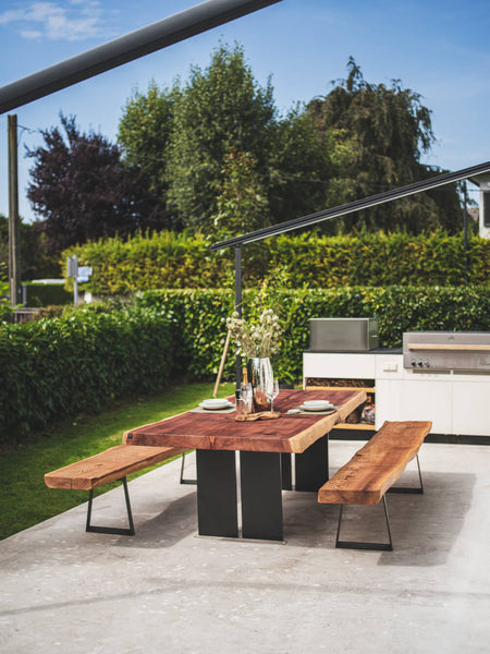 A redwood table with two matching benches with metal bases. 