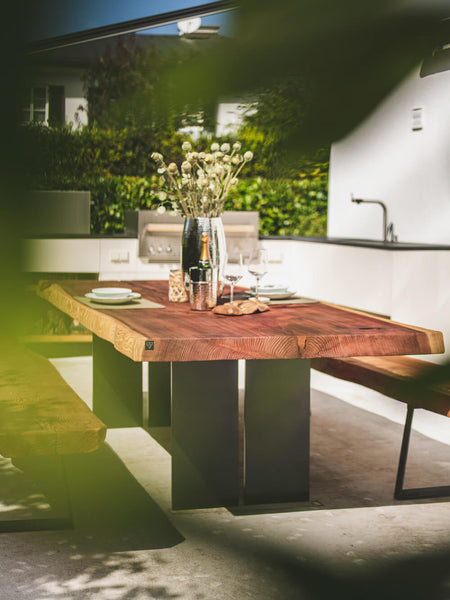 An mildly obstructed view of a redwood dining table finished with Hybrid Wood Protector.