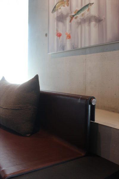 A bench in a restaurant in Belgium. The seat is made from leather while the frame of the bench itself, from wood. It was treated with Rubio Monocoat Precolor Easy Intense Black and Oil Plus 2C Charcoal for an opaque black look. 