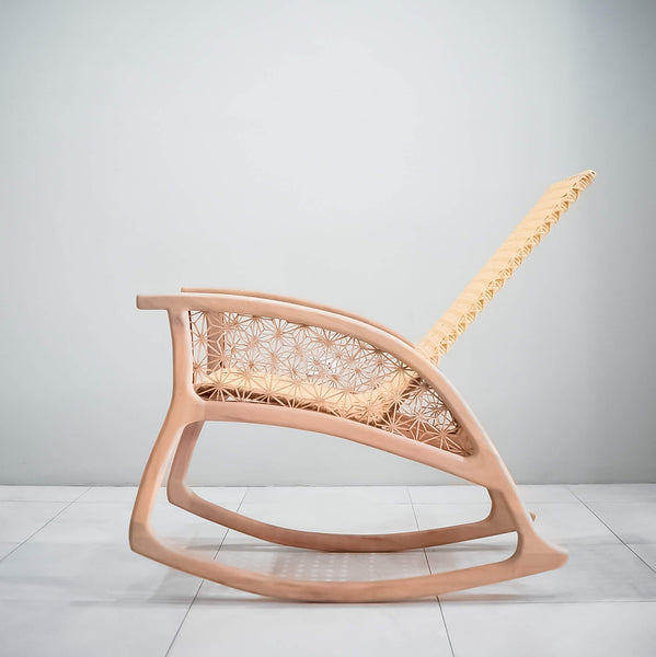 The side of a rocking chair with intricate Kumiko detail and a rattan back and seat crafted from mahogany wood and finished using Rubio Monocoat Oil Plus 2C hardwax oil wood stain and finish.