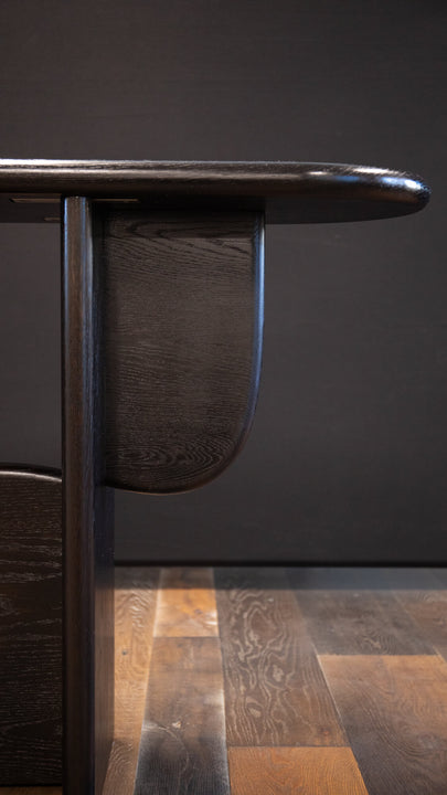 Detail on a modern white oak console table with sweeping curved features.