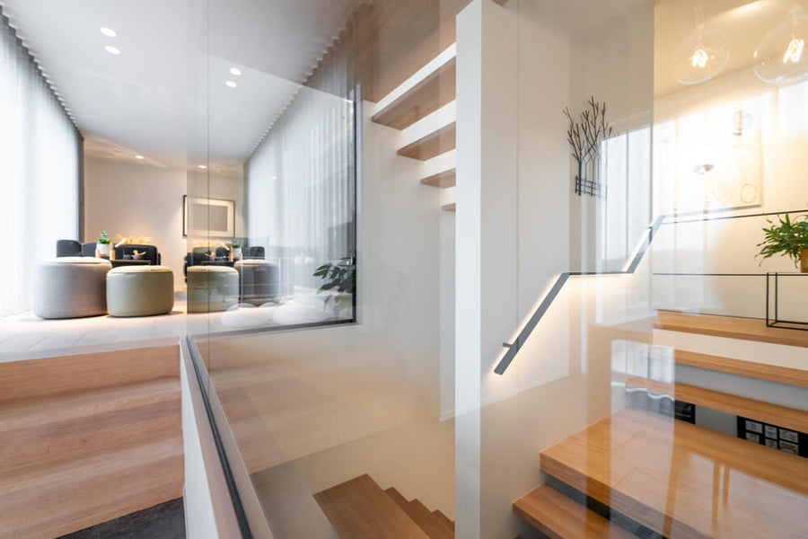 A glass-enclosed staircase made from white oak wood finished with Rubio Monocoat hardwax oil.