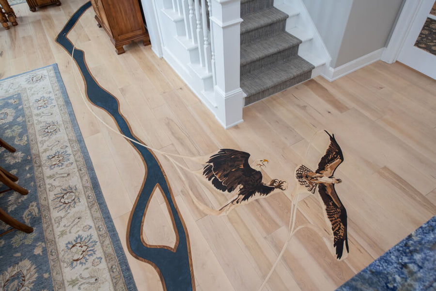 Wood inlaid osprey and eagle fighting in hardwood flooring.