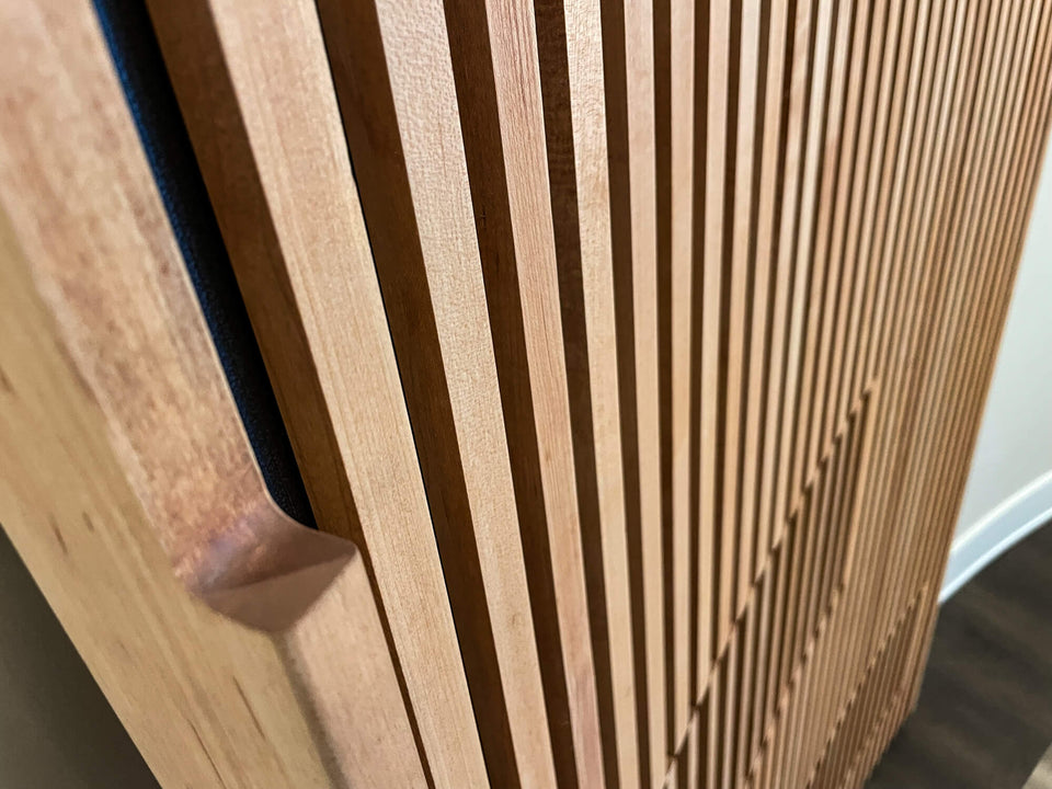The integrated handle of a curved slatted maple door finished with a hardwax oil finish.