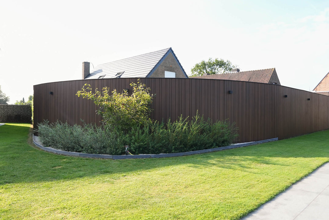 Landscaping in front of thermo ayous wood fencing finished with DuroGrit, an exterior wood stain and sealer in one.