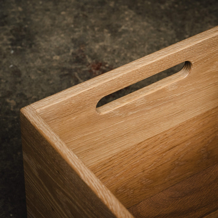 Macro close-up of a white oak storage cube's cutout handle, highlighting fine wood grain and craftsmanship under a Rubio Monocoat Oil Plus 2C Dunes finish.