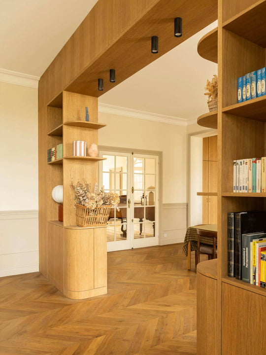 Curved white oak room divider with built-in bookshelves finished in Rubio Monocoat Oil Plus 2C Pure, herringbone hardwood floor