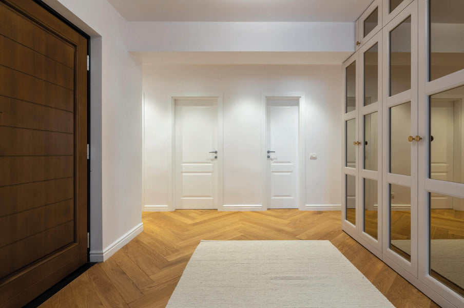 Large clean entry with herringbone flooring.