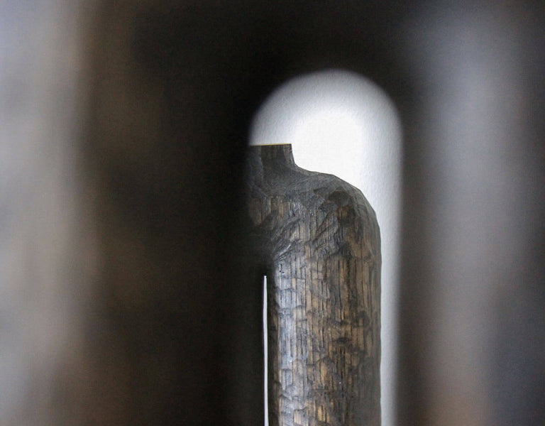 Looking through the center of a hand carved wooden vase made from white oak.