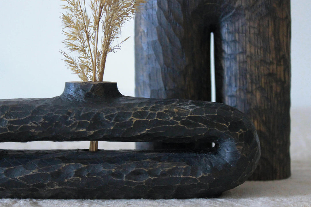 An oblong hand carved wooden vase.