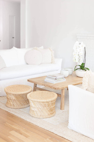 Natural looking wood coffee table between two white couches