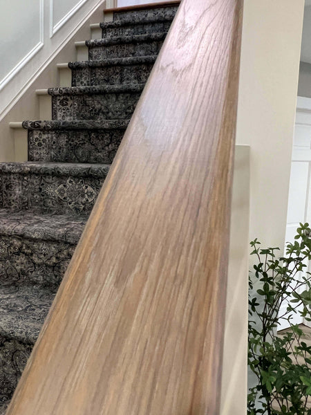 A close up of the grain of white oak stair railing.