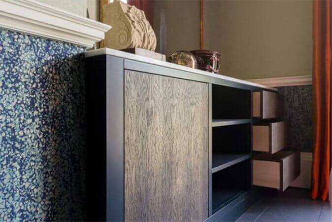 Modern dresser with wood paneling in front.