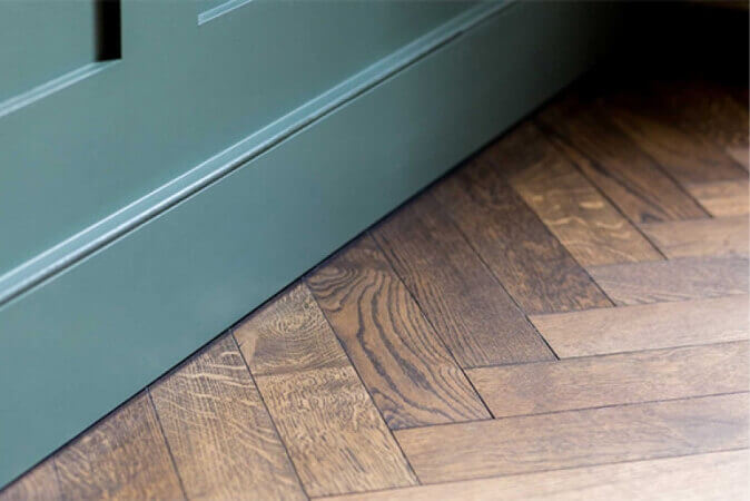 Dark oak herringbone hardwood flooring with teal teal.