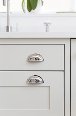 Drawer pulls on a white shaker cabinet.