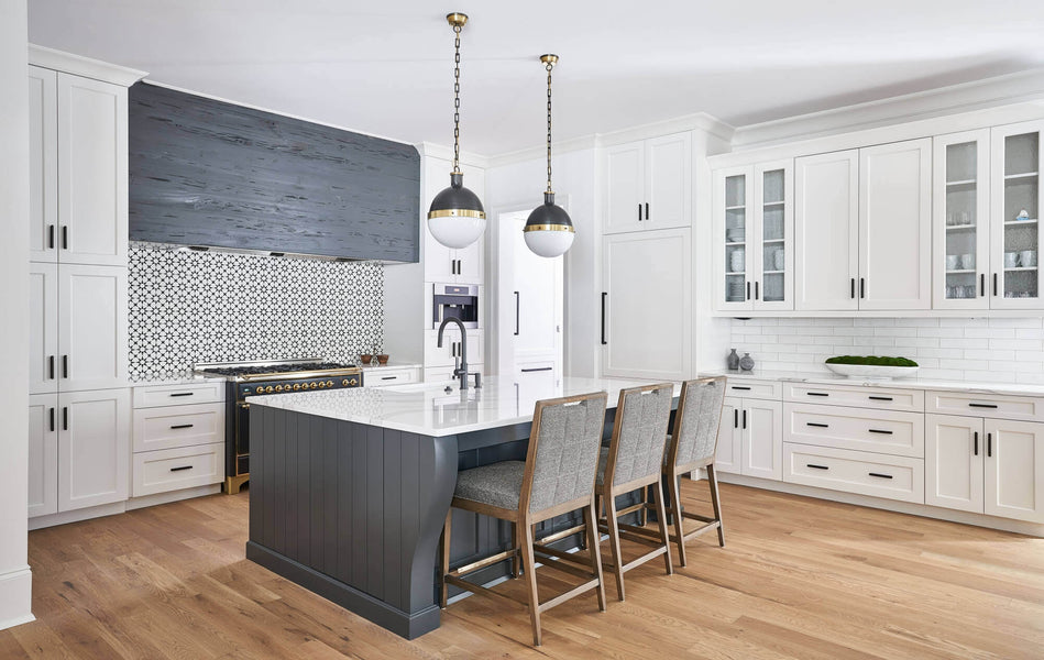 Beautiful light kitchen with natural wood flooring, white cabinets, and grey island and range hood.