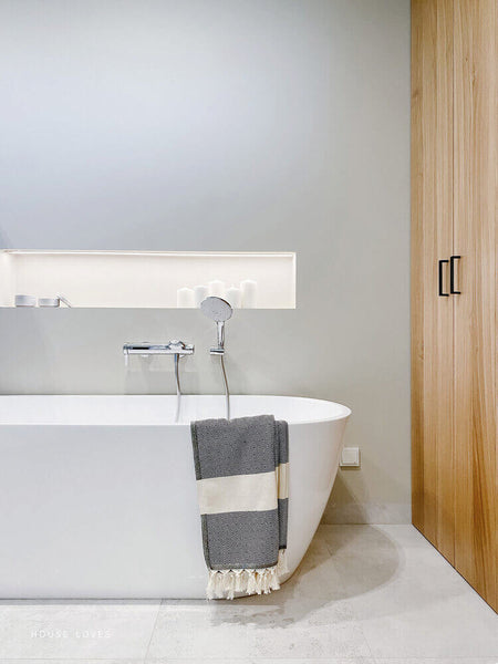 Bathtub in bathroom with large oak cabinets.
