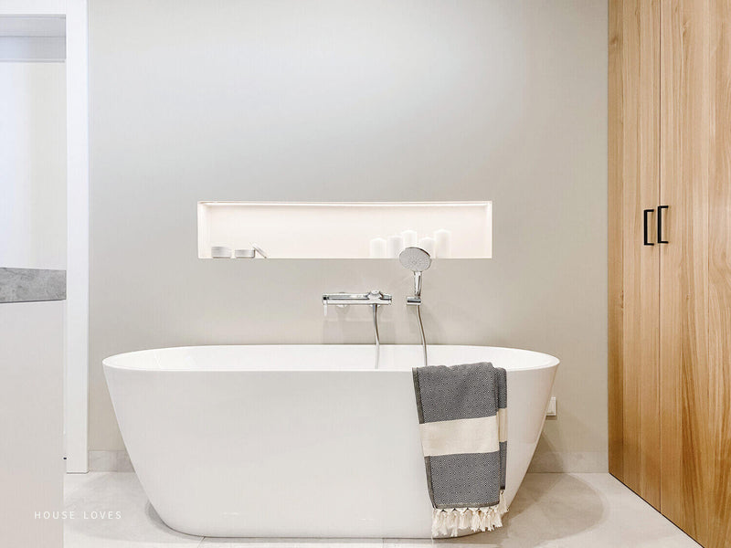 Bathtub in bathroom with large oak cabinets.
