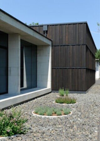 A rock garden beside a house with spruce wood siding finished using an exterior grade wood oil finish.