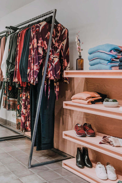 Blush pink clothing store display rack.