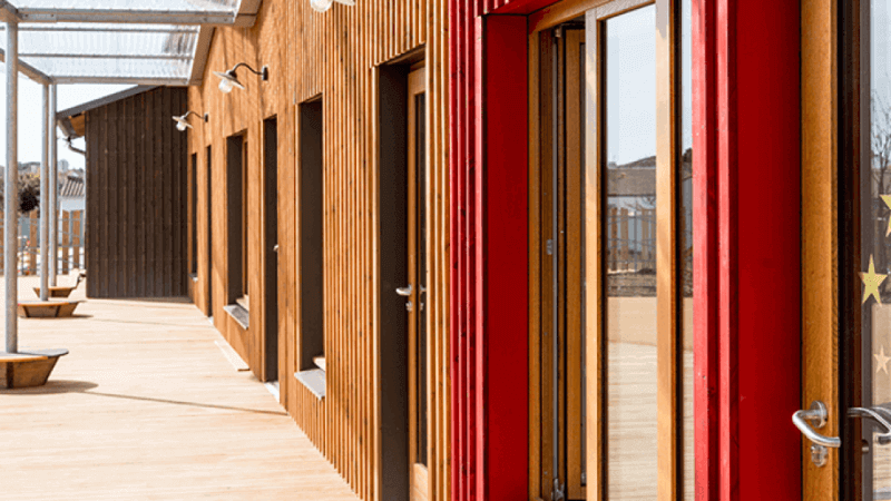 Daycare classrooms are distinguished from the outside by the exterior wall color, which are turned bright colors using Rubio Monocoat Hybrid Wood Protector.
