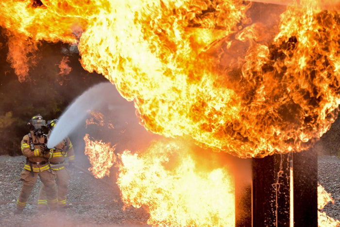 Firefighter battling a blazing wood fire