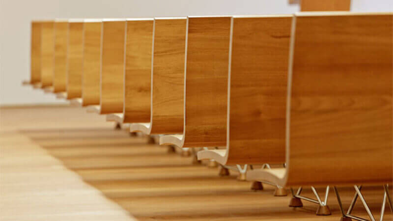 Rows of wood pews that are coated with the wood finish Rubio Monocoat.