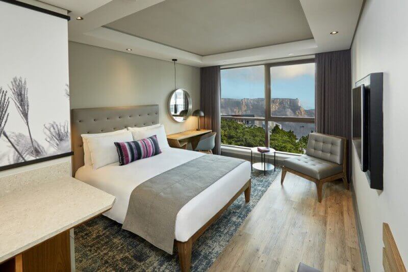 A hotel bedroom with hardwood flooring and a durable wood finish.