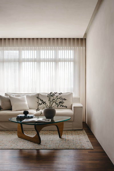 This living area features a glass and wood coffee table and beautiful white sofa.