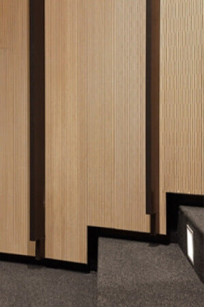 Acoustic wood paneling that contours steps in an auditorium.