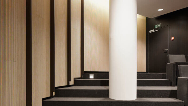 A wall of wood acoustic treatment panels finished with Oil Plus 2C wood finish in a large auditorium