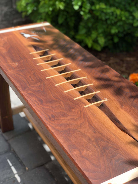 Splines of hard maple inlaid in a walnut bench.