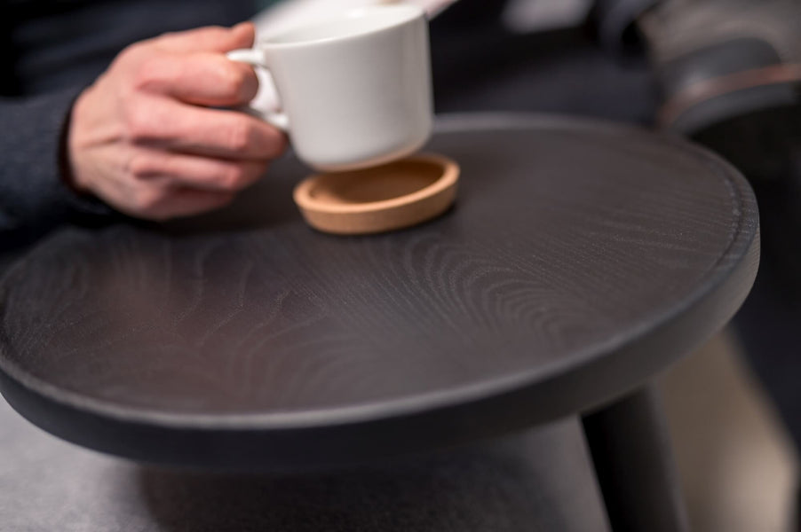 Ash coffee tray with a man sitting a coffee mug down on it.