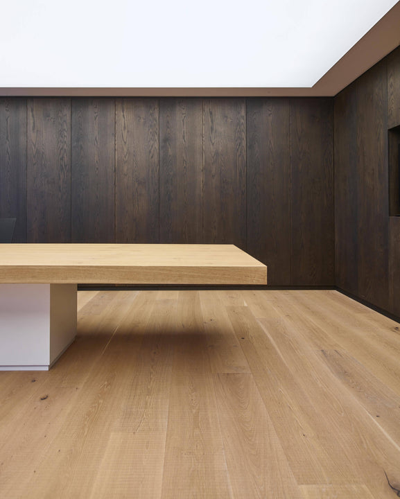 Offices at the Rubio Monocoat headquarters with light wood flooring and dark wood wall panels.